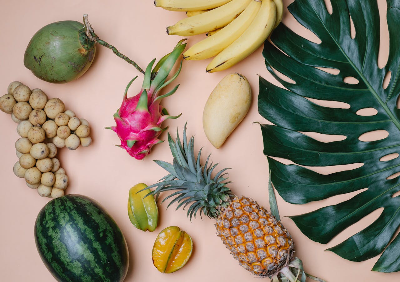 gallery-04 A vibrant composition showcasing a variety of fresh tropical fruits arranged on a pastel background.