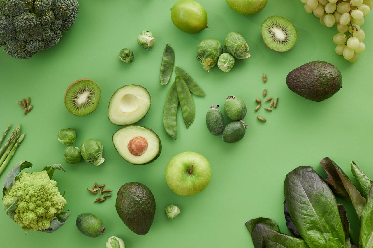 gallery-05 A variety of fresh green fruits and vegetables on a matching background, showcasing healthy organic produce.