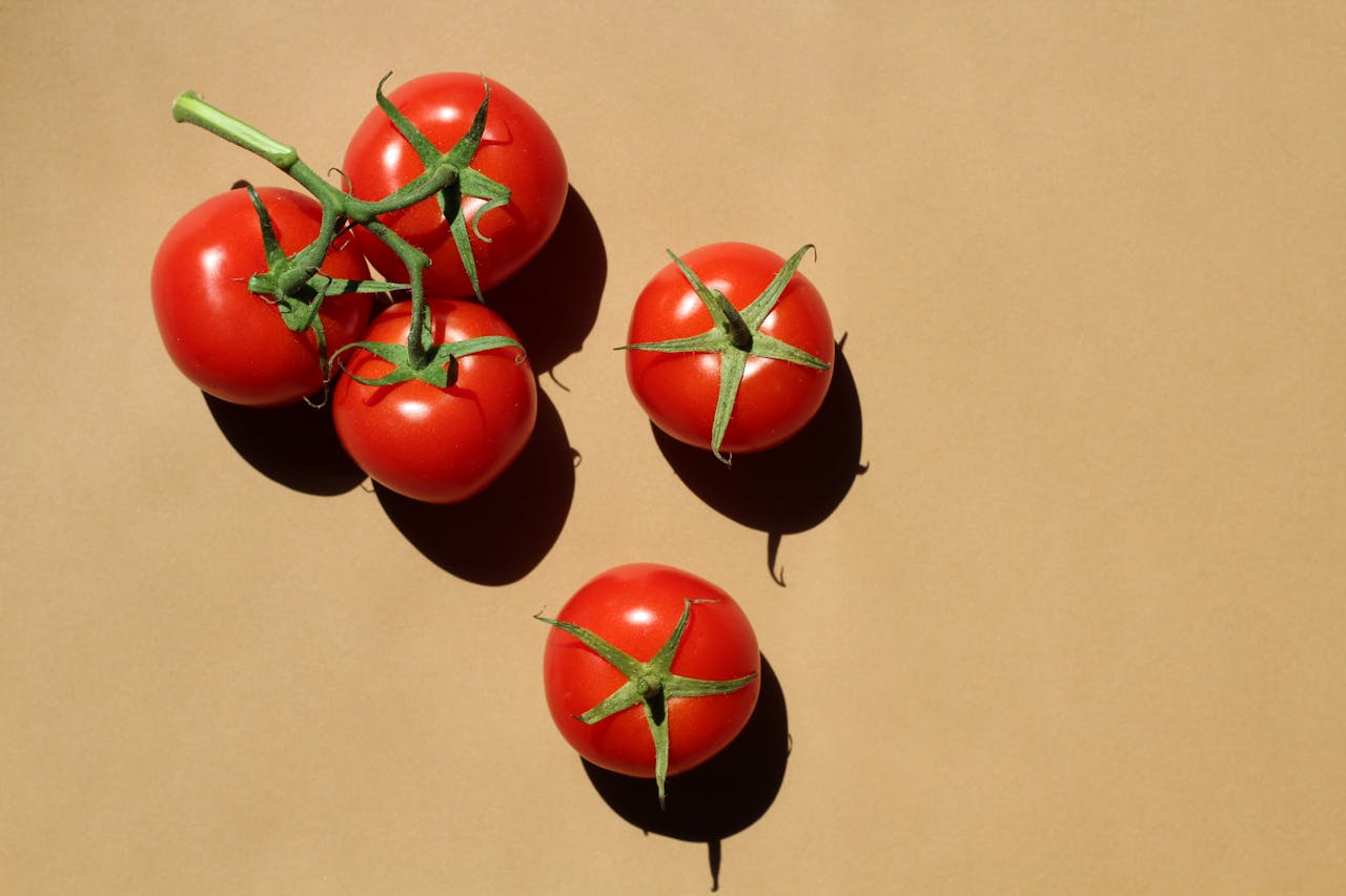 gallery-02 Vibrant cherry tomatoes arranged on a beige surface, perfect for food photography.